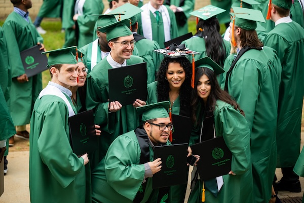 Students pose for photos at UNT's commencement ceremony