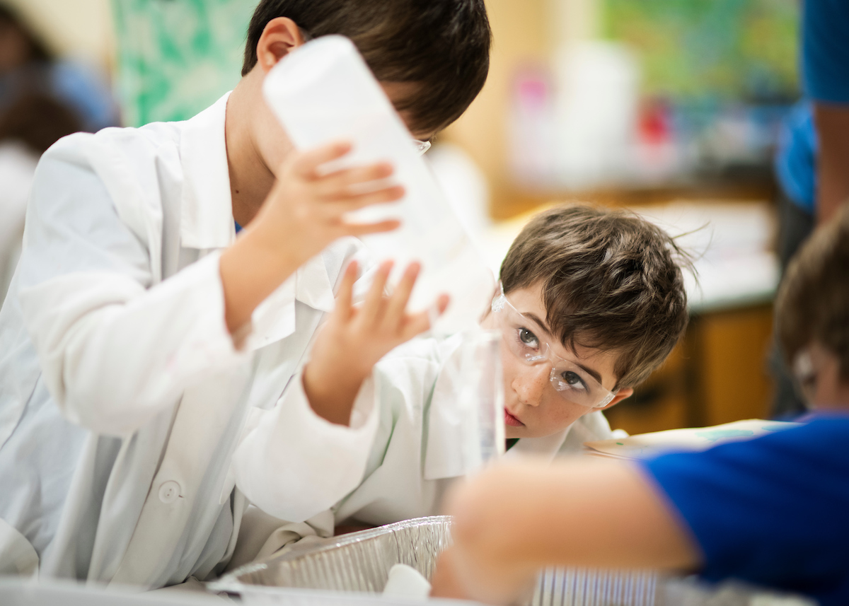 Two young boys participating in a chemistry experiment