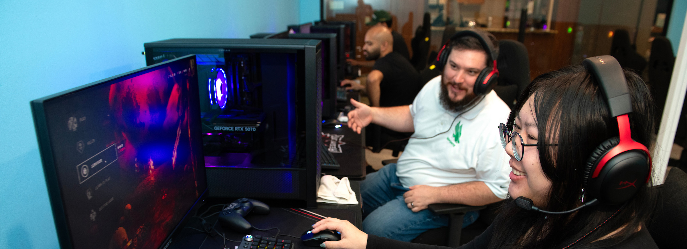 Wray (background) and a student (foreground) test the computers in the gaming center
