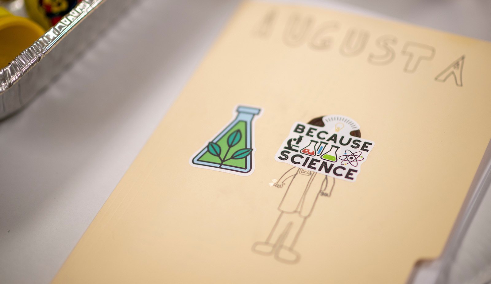 Folder with a sticker that says "because science"