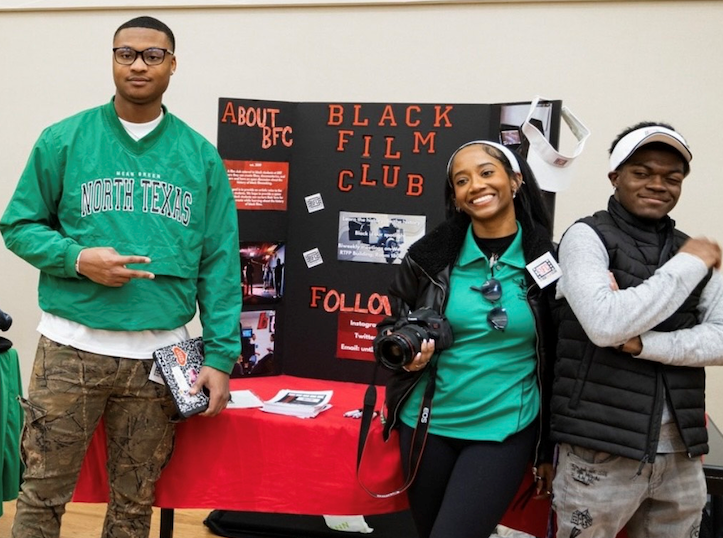 People presenting a poster for the Black Film Club