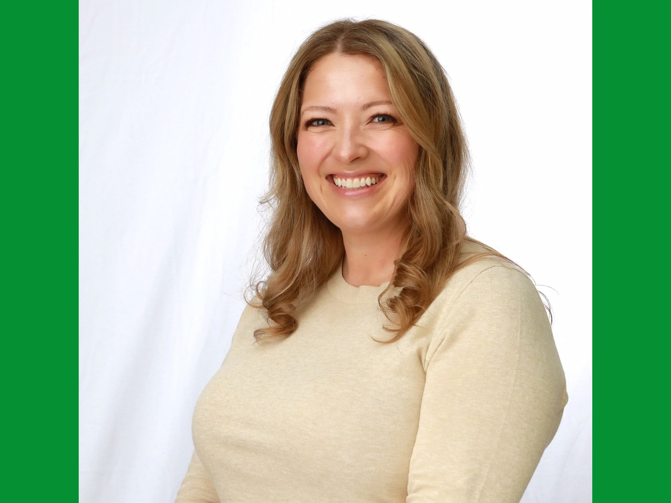 A portrait photo of a smiling woman with blonde hair.