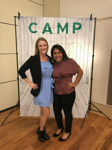 2 People posing together outside of a "Camp" sign