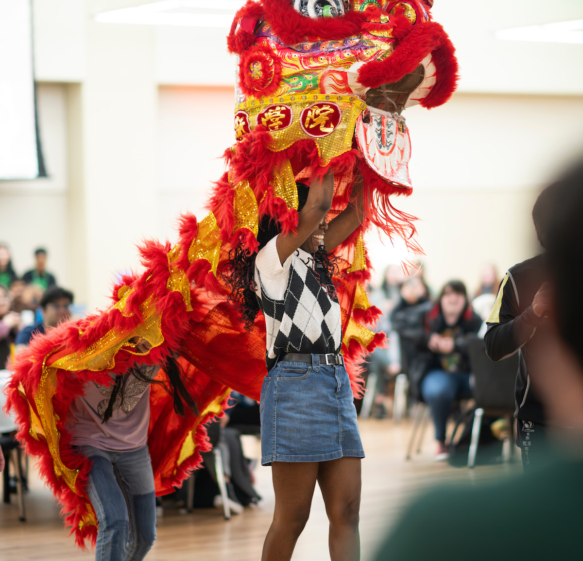 Two people holding up a Lunar New Yeear Dragon 