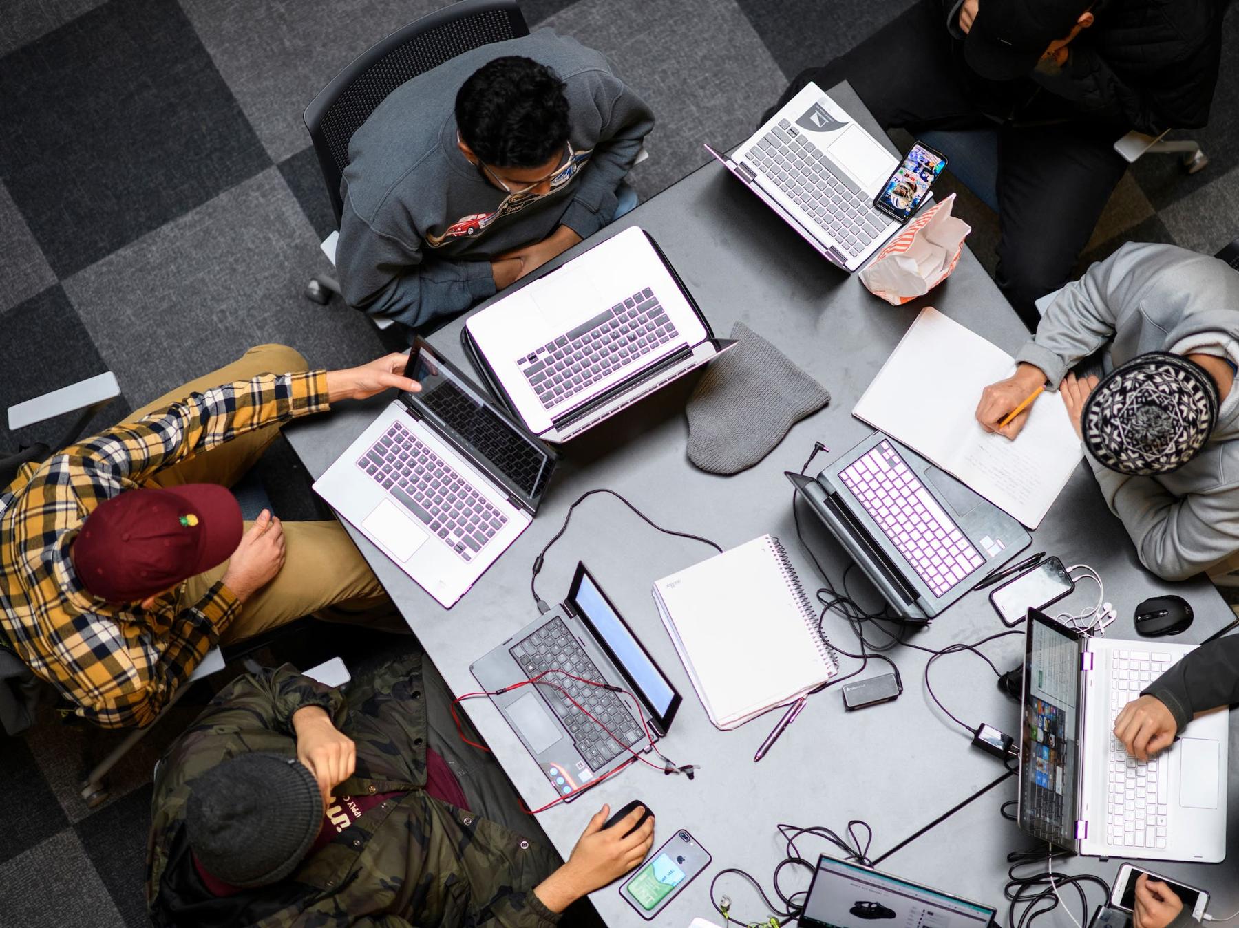 People sitting around a table on their laptops