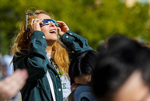 Person watching the eclipse through eclipse glasses