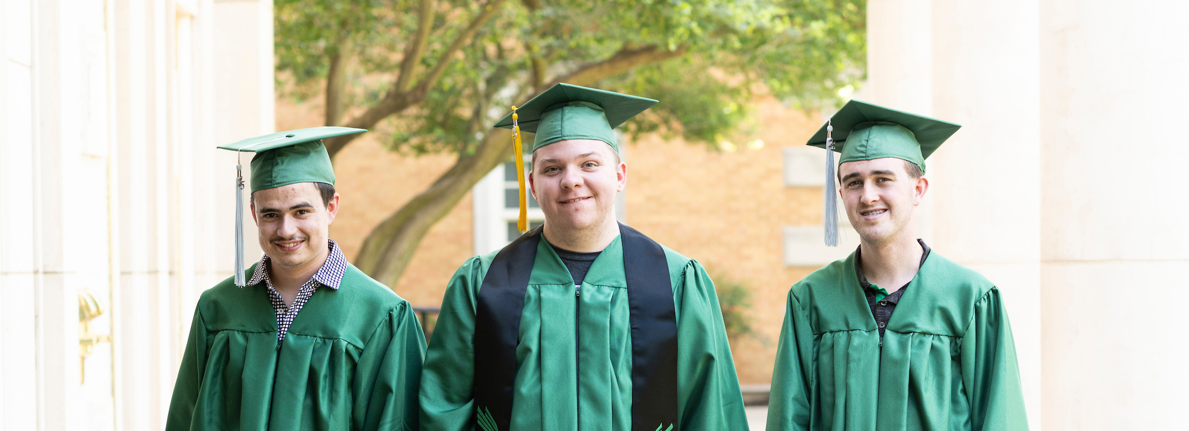 John Martin, Alex Bartolo, and Noah Rahn dressed in UNT regalia