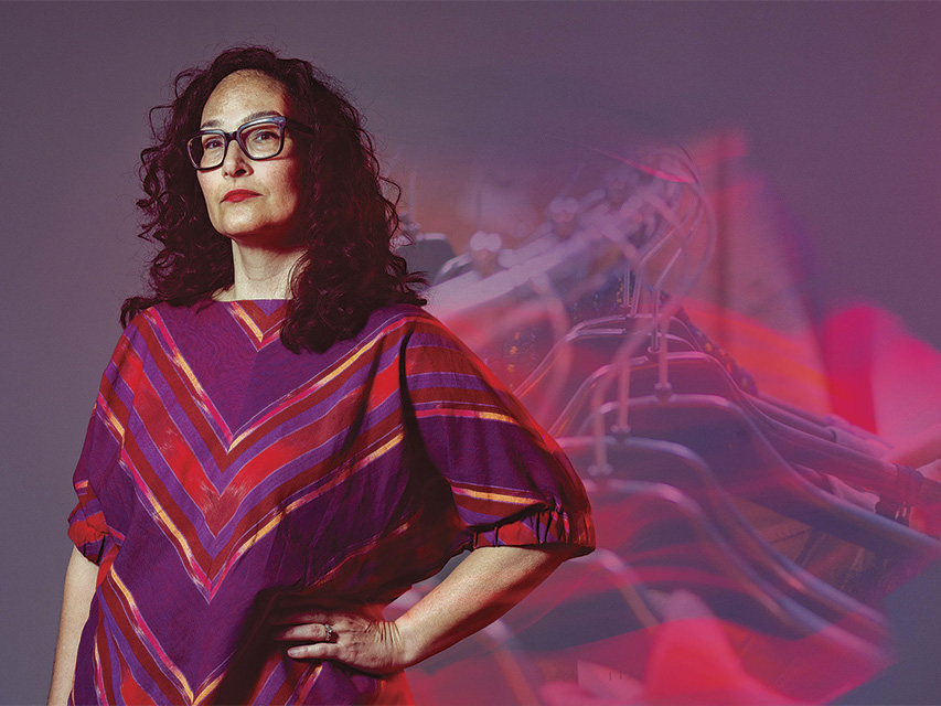 Michele Alford stands in front of an opaque clothes rack