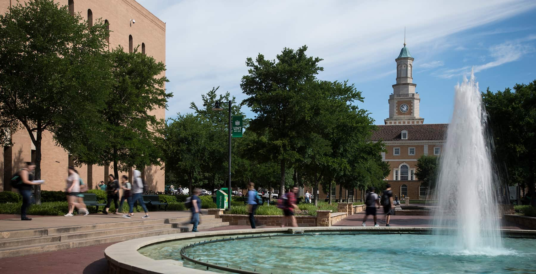 Students walk past a water fountain near the UNT Hurley Administration Building