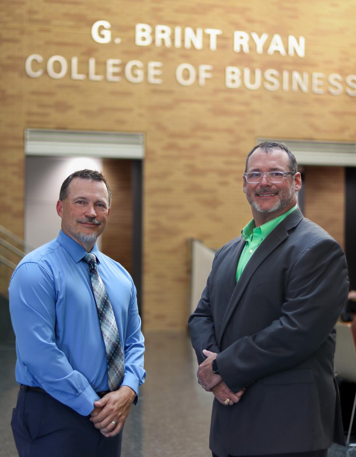 Brian Sauser and Clint Purtell standing outside the College of Business building