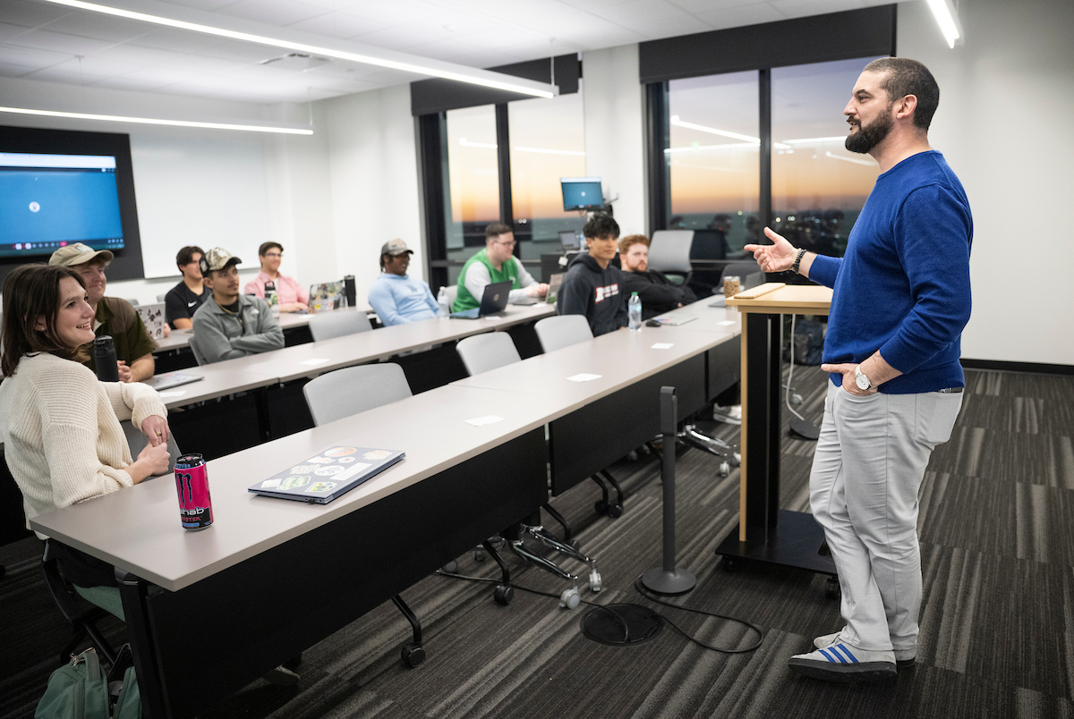 Joe Trahan stands at the front of a classroom teaching a sports media course