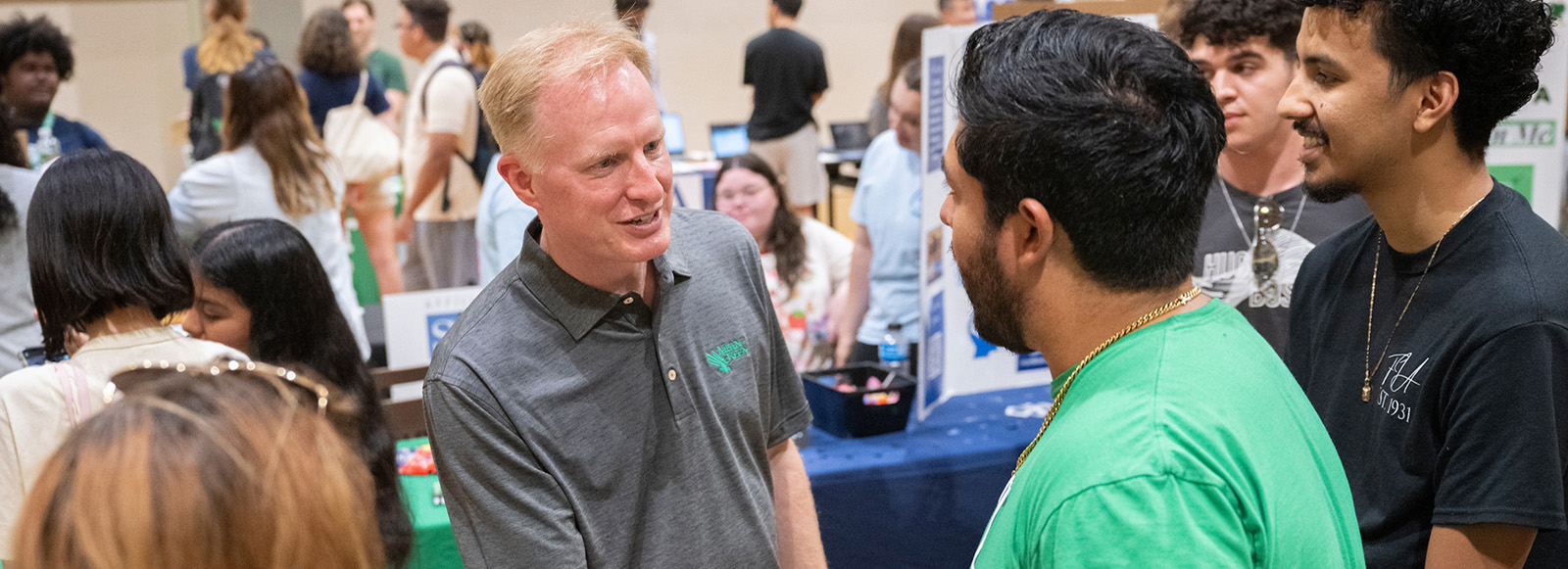 President Harrison Keller greets students