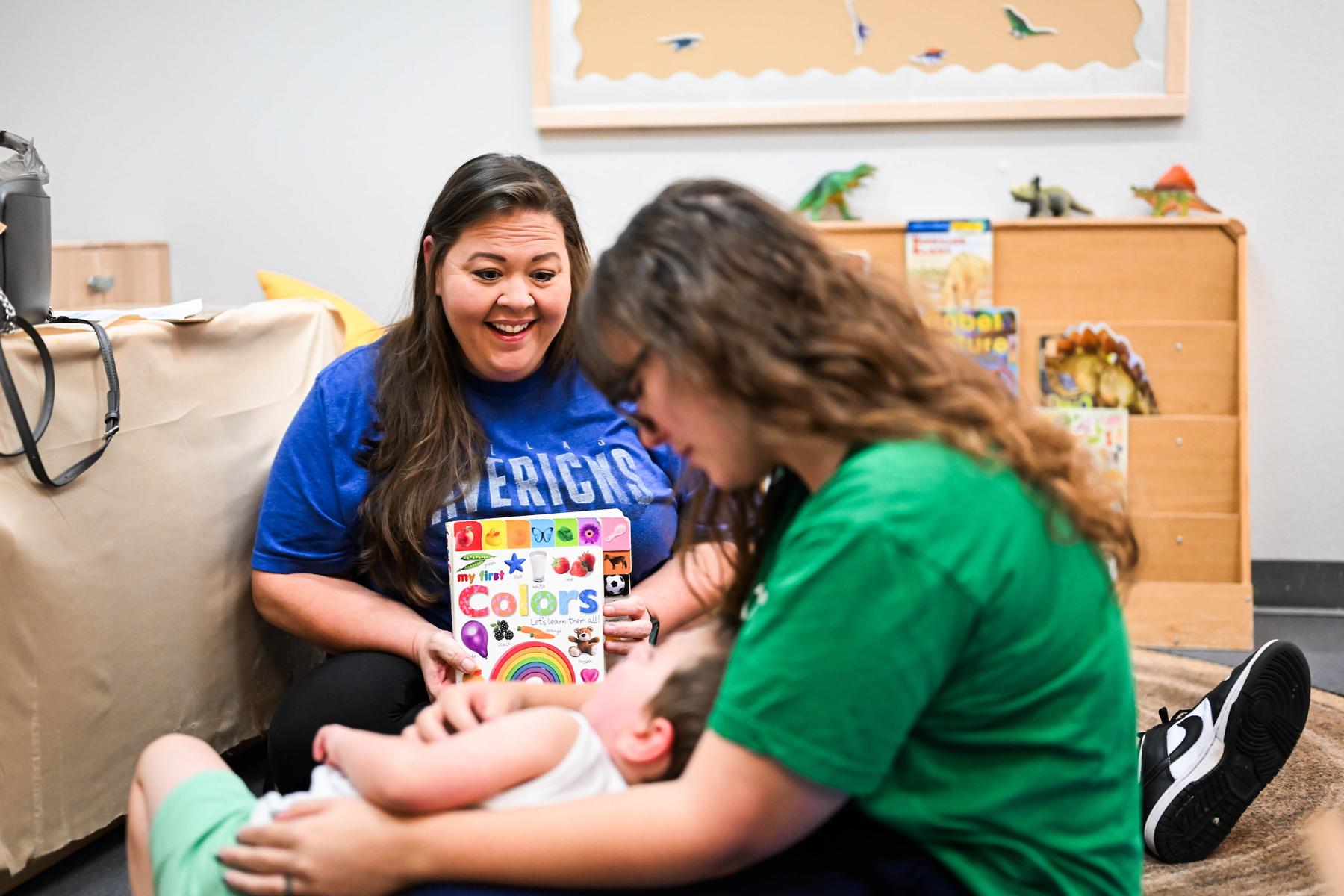 Two students working with a young child at the Autism Center