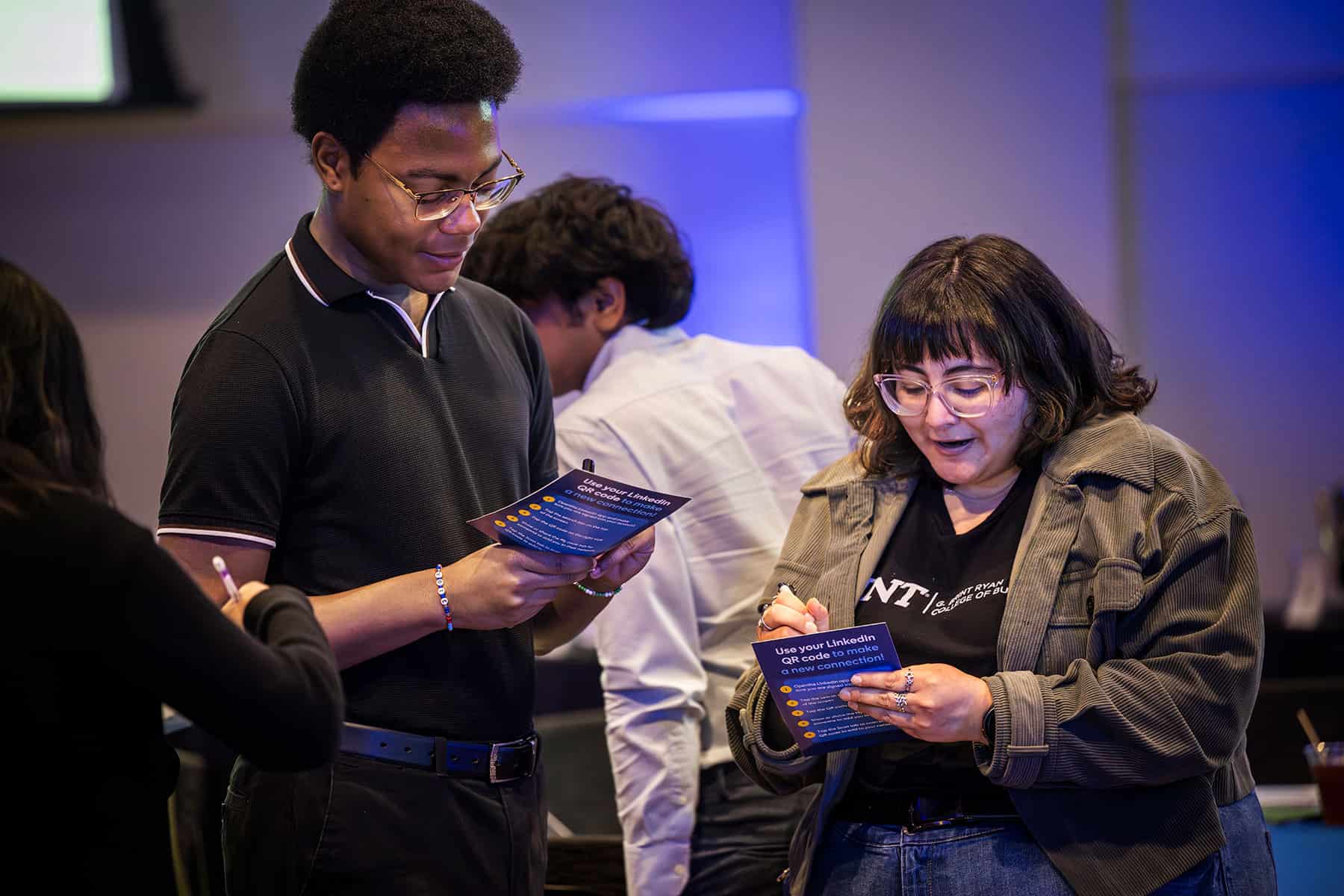 Two students read pamphlets at an event hosted by LinkedIn