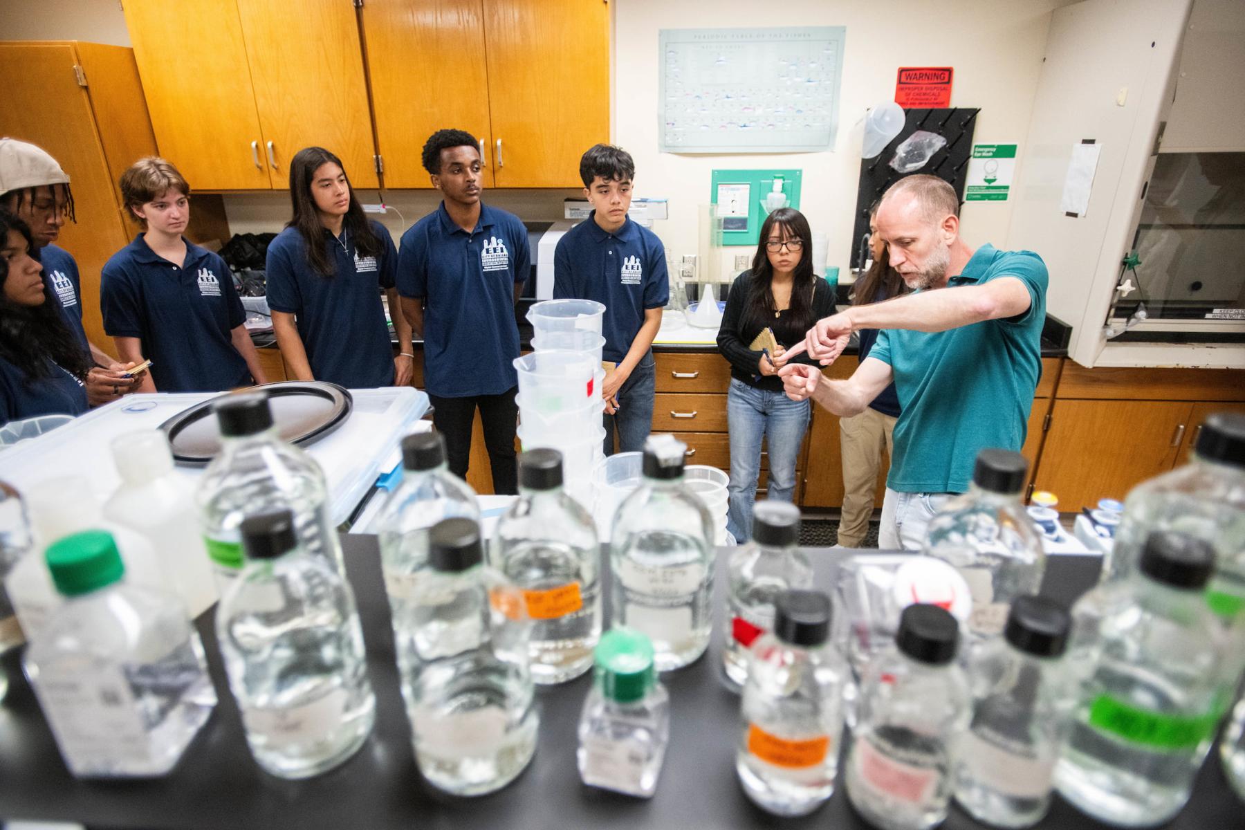 Students looking at various bottles of water