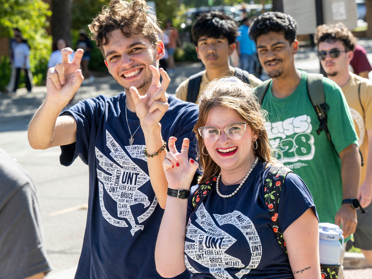 New UNT students make the eagle claw hand sign