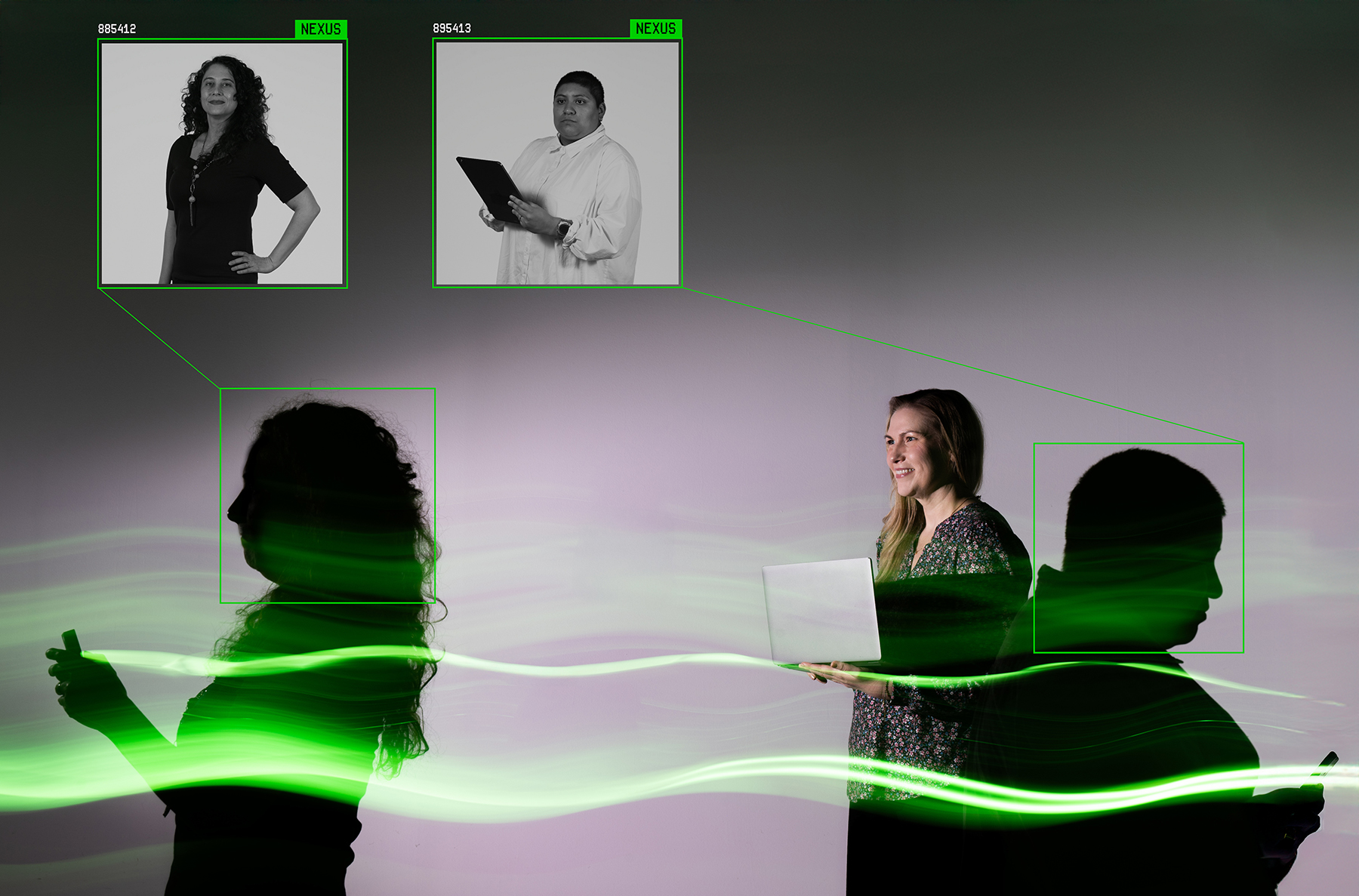 A person stands holding a laptop, flanked on both sides by two people in silhouette, each holding electronic devices.