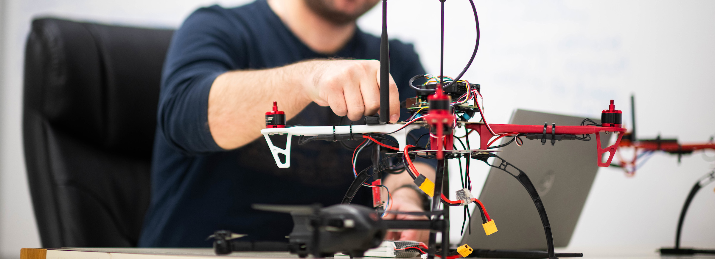 A drone on a desk being worked on by a man