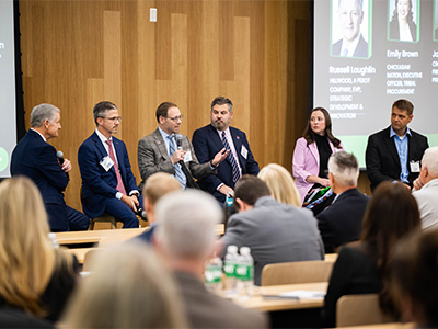 People speaking at an event, sitting down in a circle