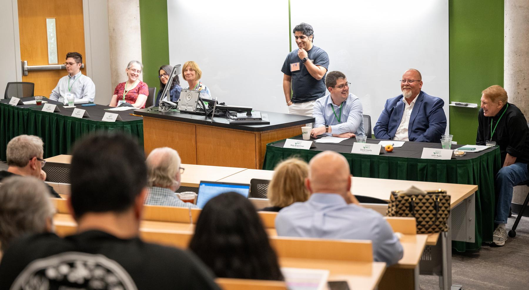 A panel of speakers in front of a classroom.