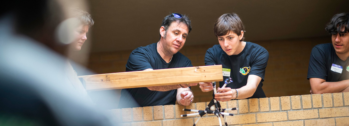 A student and UNT lecturer prepare to drop an egg in a safety harness
