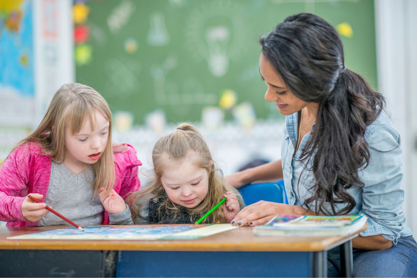 Teacher helping two children learn