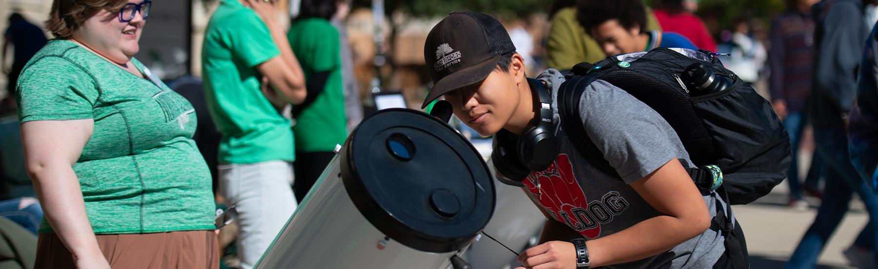 Person looking through a telescope