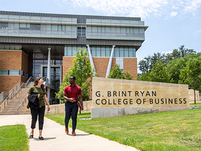 Students walking outside the G. Brint Ryan College of Business building