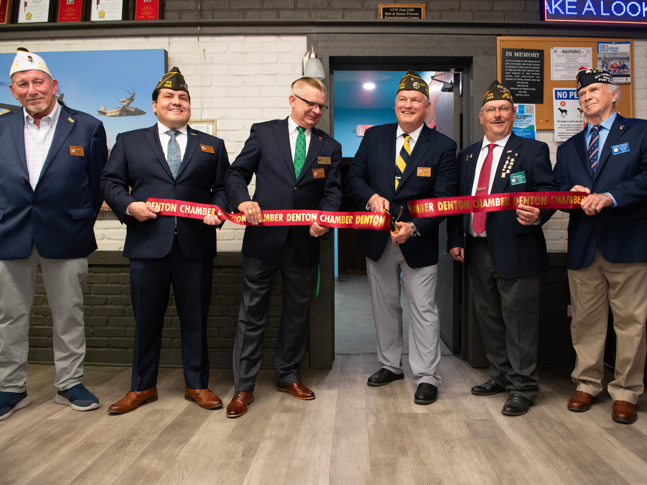 Six members of the VFW stand side by side and cut the ribbon on the new gaming center