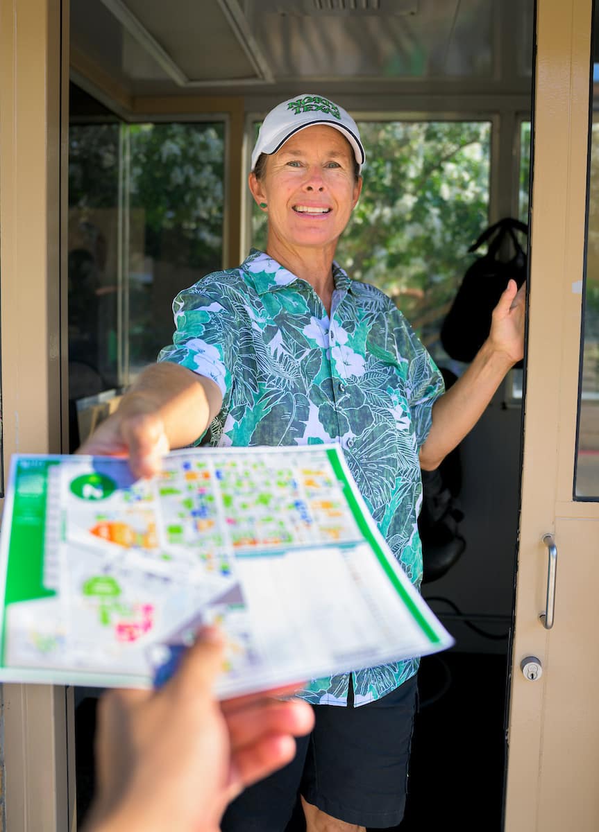 UNT employee hands student a campus map