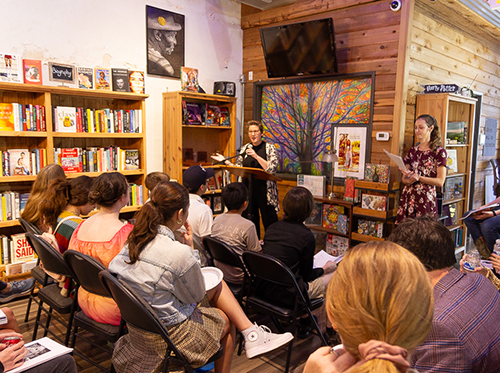 Students gathered around a podium in a local bookstore