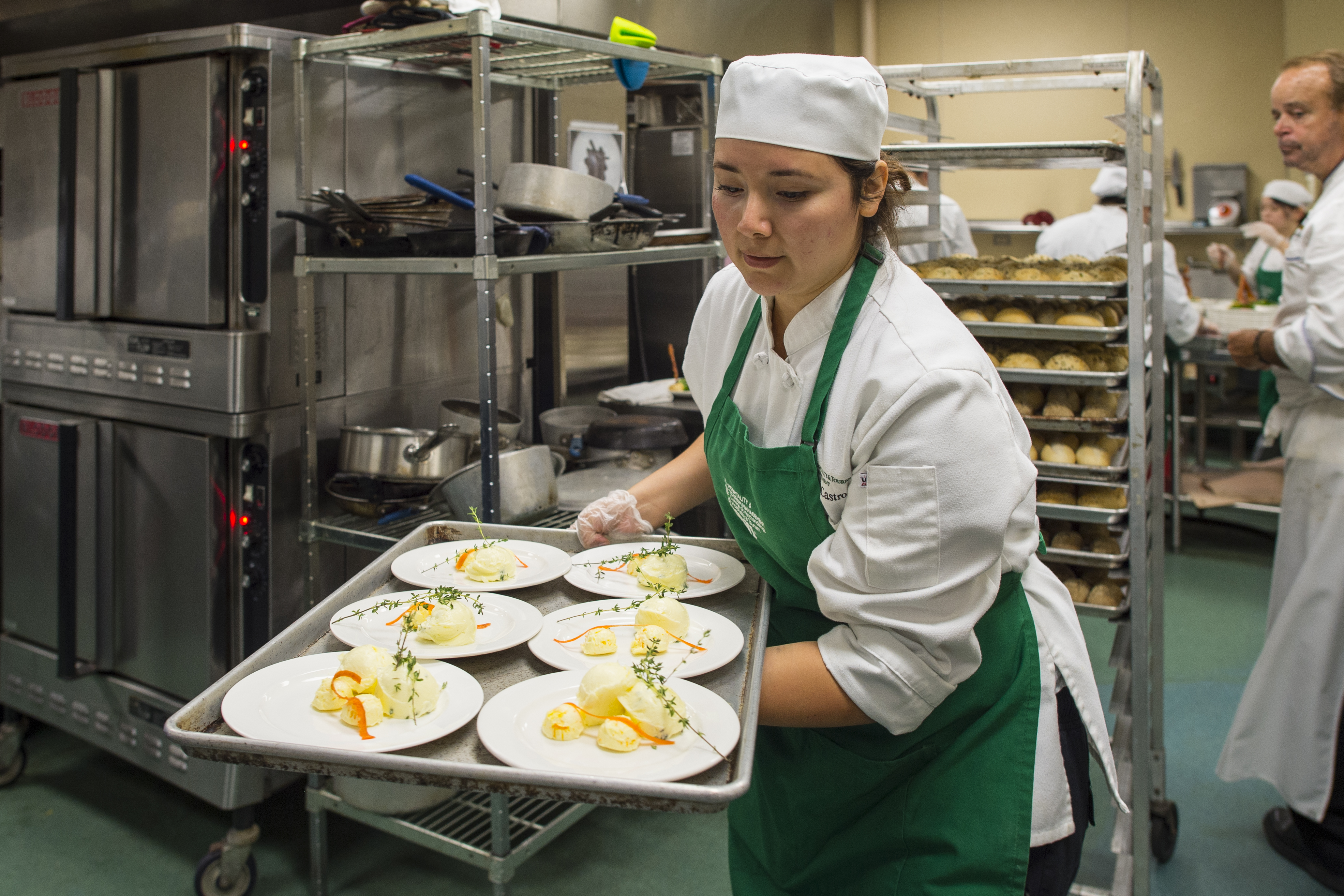 A hospitality student helps prepare a gourmet meal at UNT's Club at Gateway, a student-run restaurant that provides experience in running a successful restaurant.