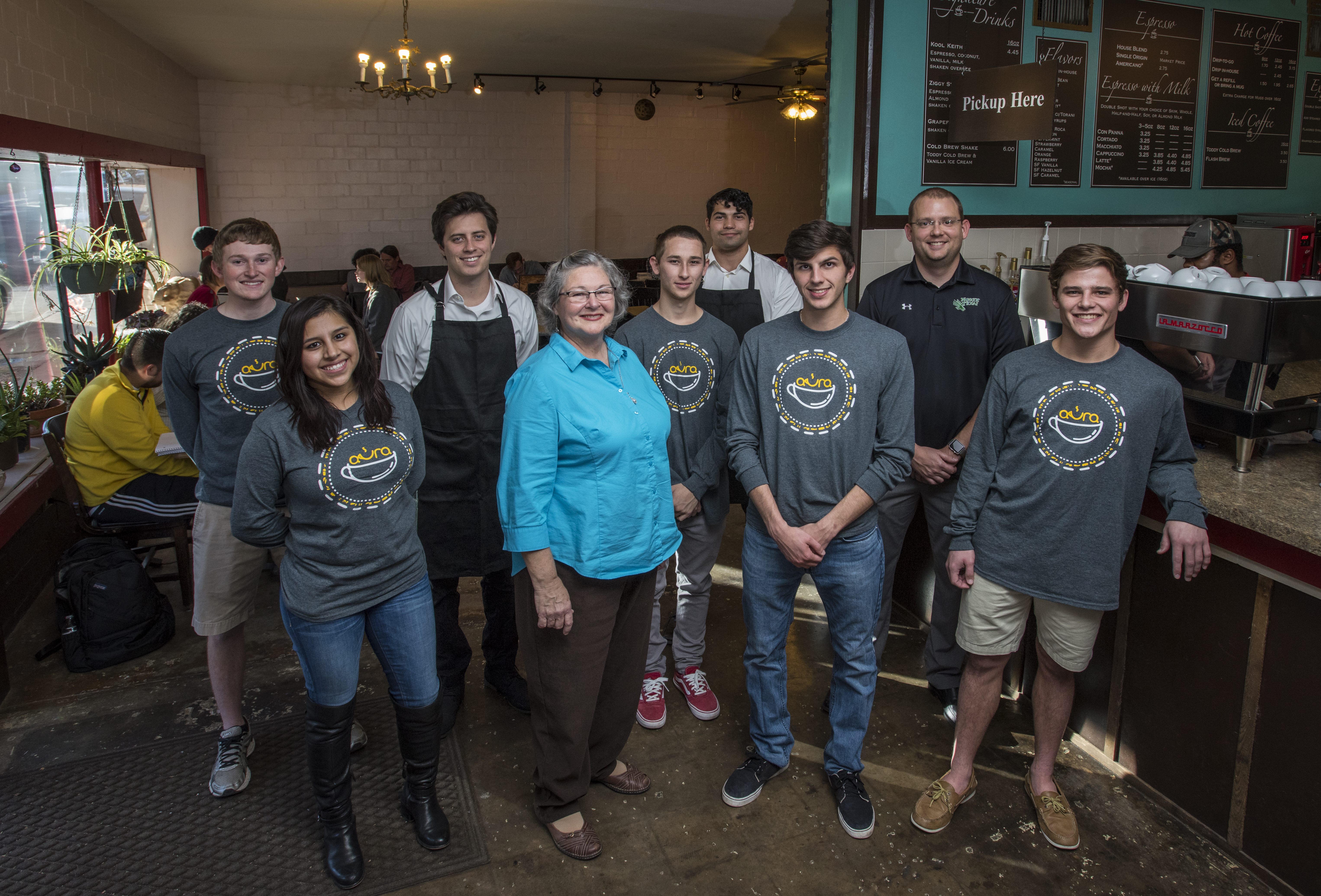 UNT senior marketing students pose inside Aura Coffee with the owner, Kim McKibben, and doctoral teaching fellow Eric Kennedy. Pictured first row: Samantha Saucedo, Kim McKibben, Benjamin Masso and Michael Begley. Pictured second row: John Michael Davis, Sam Snell, Daniel Tate, Alexander Dalaki and Eric Kennedy.