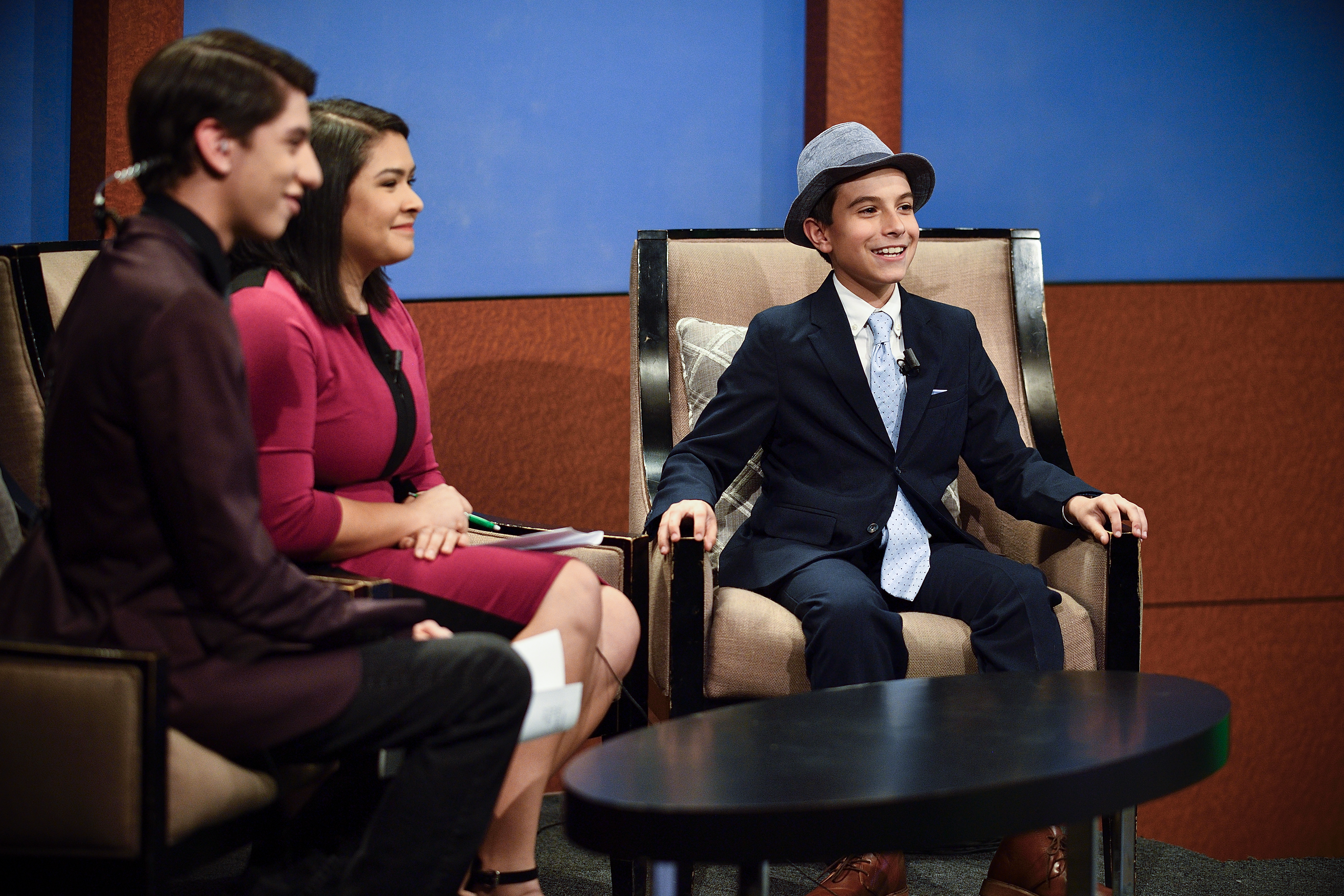 Phoenix Legg is seated in a chair next to a man and a woman, both anchors for ntTV