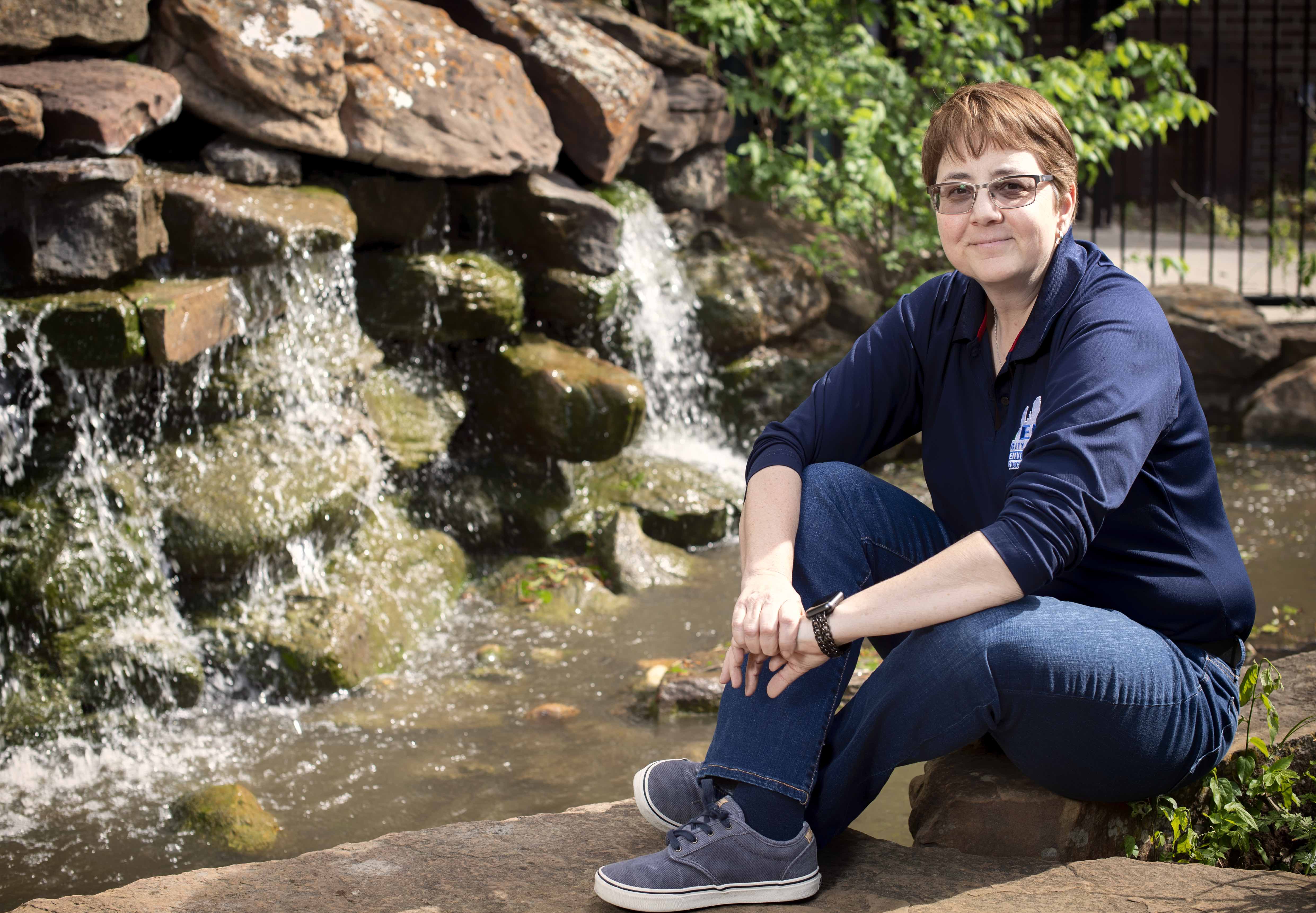 Thompson is pictured next to a small waterfall at at the Elm Fork Education Center at UNT.