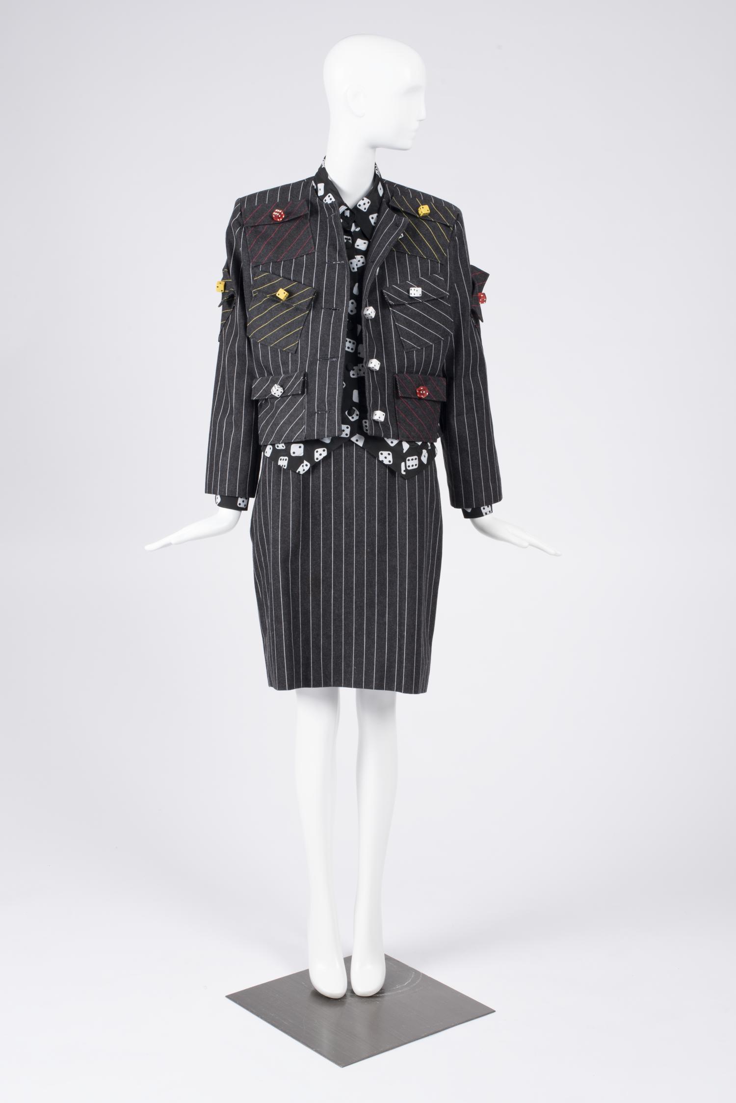 Photo of designer Patrick Kelly's pinstripe skirt suit with novelty dice print and buttons.
