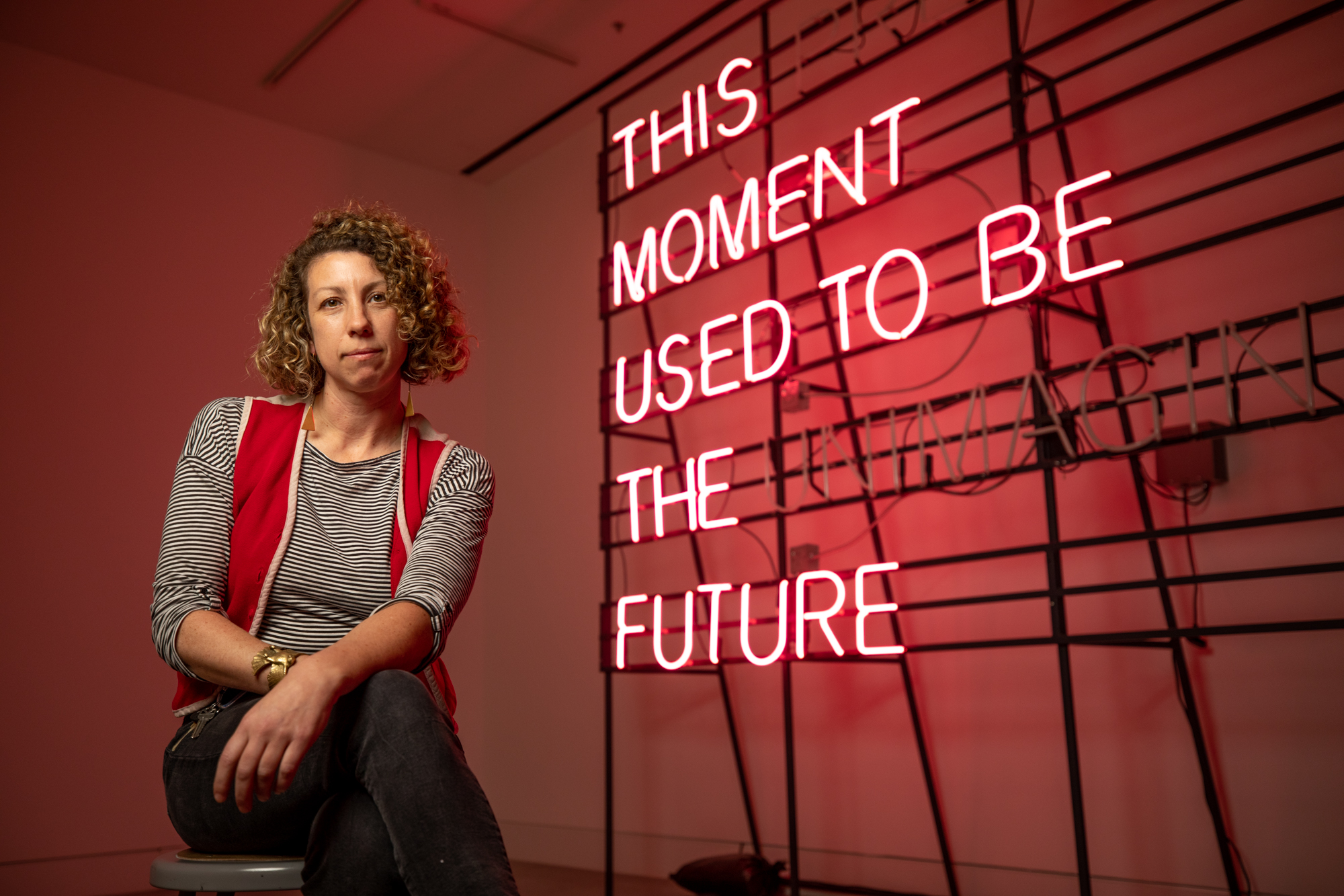 Alicia Eggert sits next to her "This Present Moment" sculpture 